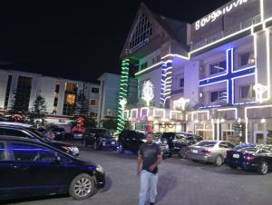 a man standing in a parking lot in front of a building at Bougainvillea Hotels in Port Harcourt