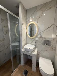 a bathroom with a sink and a toilet and a mirror at Douskos Uptown Living in Hydra +46 photos