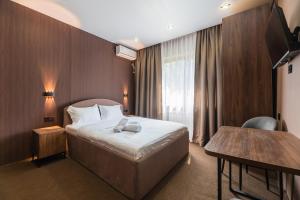 a hotel room with a bed and a table at MIRAFI Hotel in Almaty