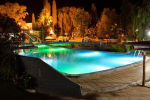 a large swimming pool at night with a wooden ramp at Cristal Hotel in Eduardo Castex