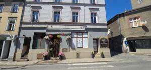 a building on a street with flowers in the window at Residence APOLLO MJ z dwoma pokojami in Ząbkowice Śląskie