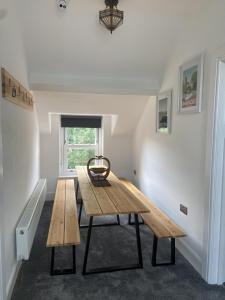 a wooden table in a room with a bench at Martris House in Rhayader +5 photos