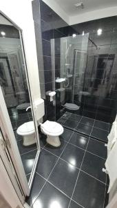 a bathroom with two toilets and a shower at Coquette in Petrila