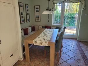 a dining room with a wooden table and chairs at Haus Sonnengarten in Brokstedt