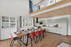 a kitchen and dining room with a table and red chairs at FeWo Nägeleried - Große Galerie-Wohnung mit Balkon, Heimkino, Garten in Sulzberg
