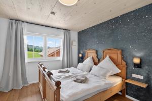a bedroom with a bed with a starry wall at FeWo Nägeleried - Große Galerie-Wohnung mit Balkon, Heimkino, Garten in Sulzberg