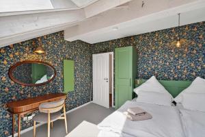 a bedroom with a bed and a desk and a mirror at FeWo Nägeleried - Große Galerie-Wohnung mit Balkon, Heimkino, Garten in Sulzberg