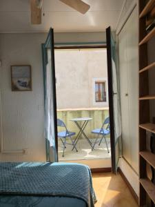 a bedroom with a bed and a view of a patio at Chez Anna et Mat in Sérignan