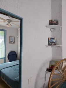 a mirror in a bedroom with a bed and a chair at Chez Anna et Mat in Sérignan