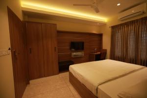 a bedroom with a bed and a television in it at Fathima Residency in Pattanapuram