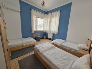 a bedroom with three beds and a blue wall at Nomads Hostel Sousse in Sousse