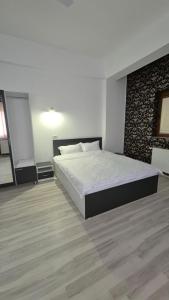 a bedroom with a large bed in a room at Coquette in Petrila