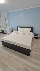 a bedroom with a large bed with white sheets and pillows at Coquette in Petrila +1 photo