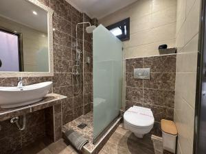 a bathroom with a toilet and a sink and a shower at Life's Moments in Limenaria