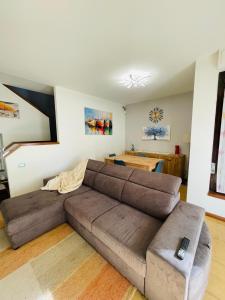 a living room with a brown couch and a table at Garda MarANDGi Home Salo' in Salò