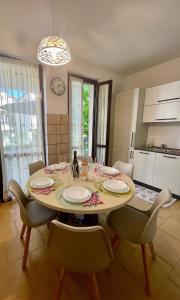a dining room with a table with chairs and a clock at Garda MarANDGi Home Salo' in Salò