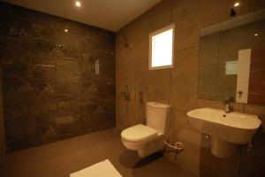 a bathroom with a toilet and a sink at Fathima Residency in Pattanapuram +13 photos