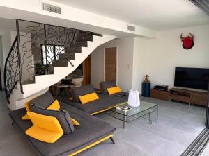 a living room with a couch and a staircase at La pointe au sel in Aigues-Mortes