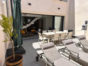 a patio with a table and chairs and a potted plant at La pointe au sel in Aigues-Mortes