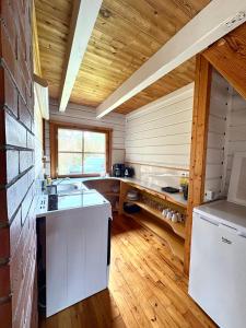 a large kitchen with wooden walls and wooden floors at Männiliiva Holiday Home with Sauna in Hiiumaa