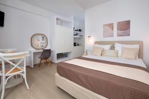 a bedroom with a bed and a desk and a chair at Sunshine Alkyoni Suite in Isterni