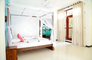 a bedroom with a canopy bed with a view of the ocean at Villa Estuary in Bentota