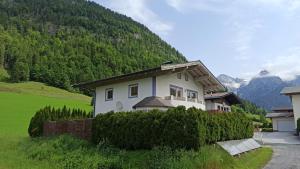 a white house with a mountain in the background at Villa Rupi in Sankt Ulrich am Pillersee