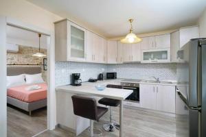 a kitchen with white cabinets and a bed in a room at Apanemia in Kallirákhi