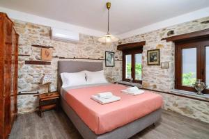 a bedroom with a bed and a stone wall at Apanemia in Kallirákhi