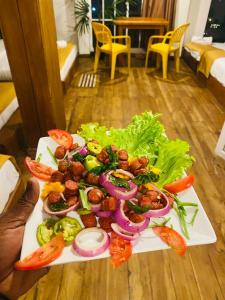 a plate of food with vegetables on a table at Infinity Winter Resort in Nuwara Eliya