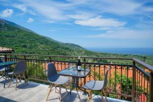 a table and chairs on a balcony with a view at Apanemia in Kallirákhi