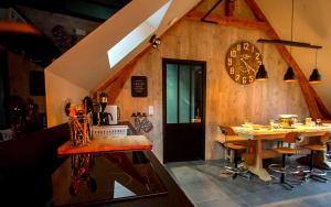 a dining room with a table and a clock on the wall at Entre ciel et montagnes in Cauterets
