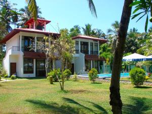 a house with a swimming pool in front of a yard at Villa Estuary in Bentota