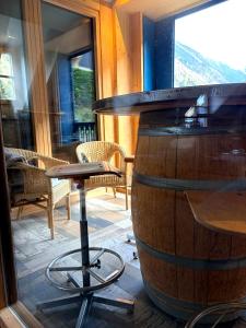 a table and a stool next to a barrel at Entre ciel et montagnes in Cauterets