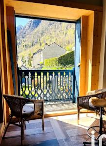 a balcony with a large window with a view at Entre ciel et montagnes in Cauterets