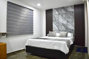 a bedroom with a bed with a painting on the wall at Hotel Santo Rio Suite Santa Marta in Santa Marta +5 photos