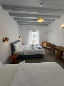 a bedroom with a large bed and a window at Nikolas Rooms in Loutro