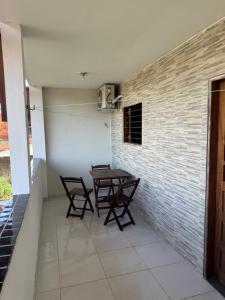 a table and chairs in a room with a brick wall at Flat Alicia mar in Tamandaré