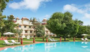 a hotel with a swimming pool in front of a building at Jai Mahal Palace in Jaipur