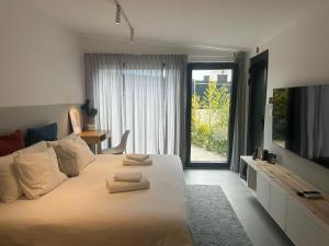 a bedroom with a large bed with two towels on it at Casa Alegria in Oeiras