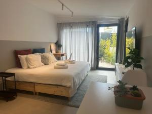 a bedroom with a bed and a large window at Casa Alegria in Oeiras
