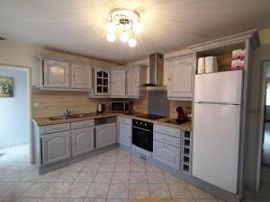 a kitchen with white cabinets and a white refrigerator at La maison du petit peintre in Villaines-sous-Lucé
