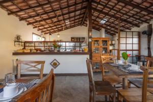 a dining room with a table and wooden chairs at Portal de Búzios in Armacao dos Buzios