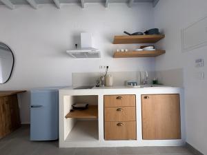 a small kitchen with a sink and a counter at Nikolas Rooms in Loutro