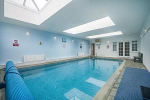 a large swimming pool in a building with a ceiling at 6 Bed in Hersham oc-t29211 in Stratton