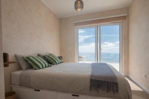 a bedroom with a large bed with a large window at Casa Conchita in Angra do Heroísmo