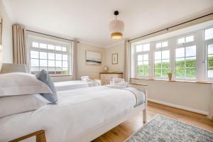 two white beds in a room with windows at 6 Bed in Hersham oc-t29211 in Stratton +38 photos