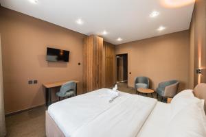 a hotel room with a large bed and chairs at MIRAFI Hotel in Almaty