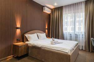 a bedroom with a bed with a stuffed animal on it at MIRAFI Hotel in Almaty +22 photos