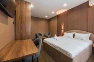 a hotel room with a bed and a table at MIRAFI Hotel in Almaty